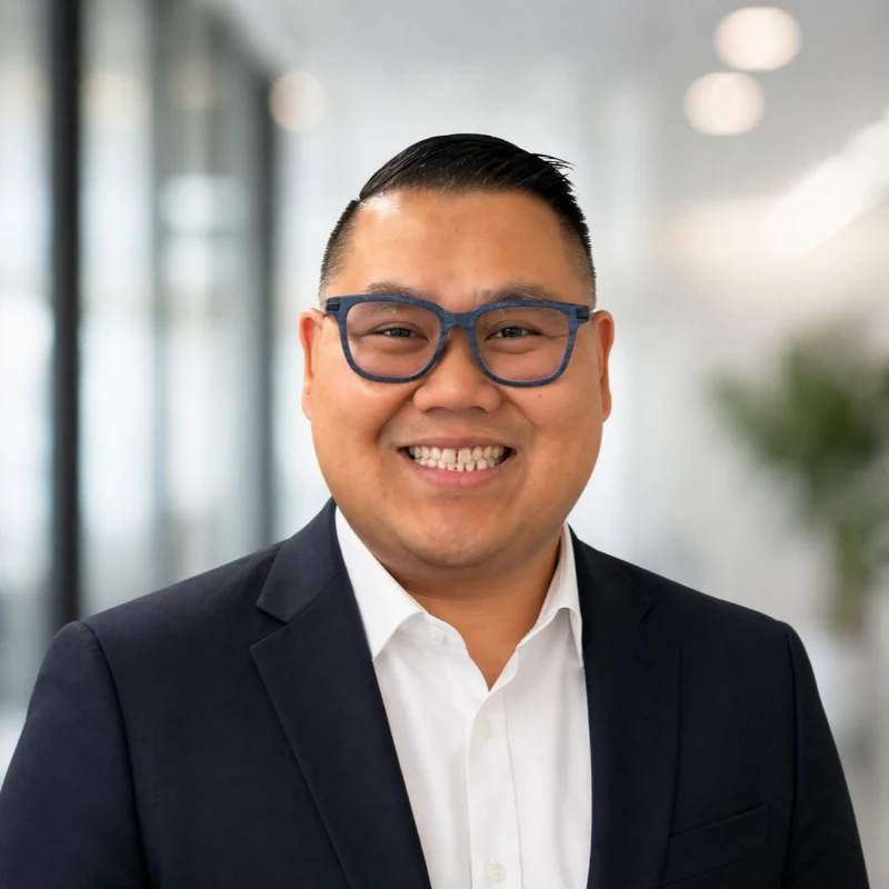 Johnny Nguyen, wearing a navy blazer and smiling